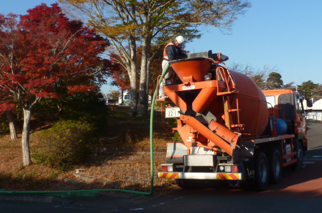 ミキサー車と紅葉した木々